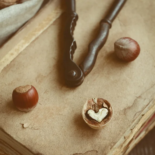 Decoración con cascanueces, nuez en forma de corazón y libros antiguos — Foto de Stock