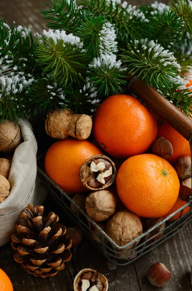 Decoración de Navidad con mandarinas, nueces y ramitas de pino —  Fotos de Stock