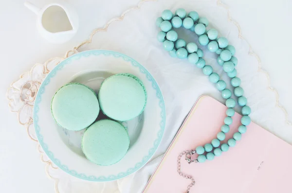 Mint macaroon and teal beads on light background — Stock Photo, Image