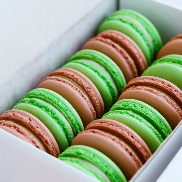 Conjunto de pistache e macaroon caramelo em caixa branca, quadrado — Fotografia de Stock