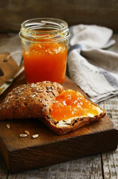 Marillenmarmelade-Sandwich mit Sonnenblumenkernen auf Schneidebrett — Stockfoto