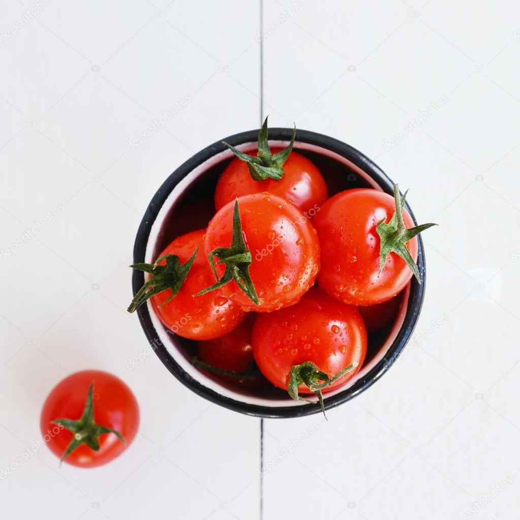 Ripe chery tomatoes on white wooden background, square