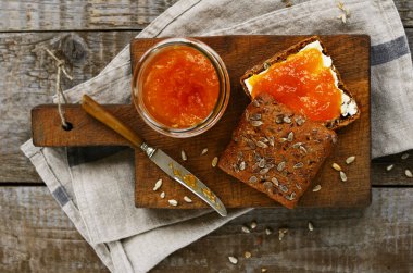 Çavdar ekmeği ve kayısı sandviç kesme tahtası üzerinde reçel
