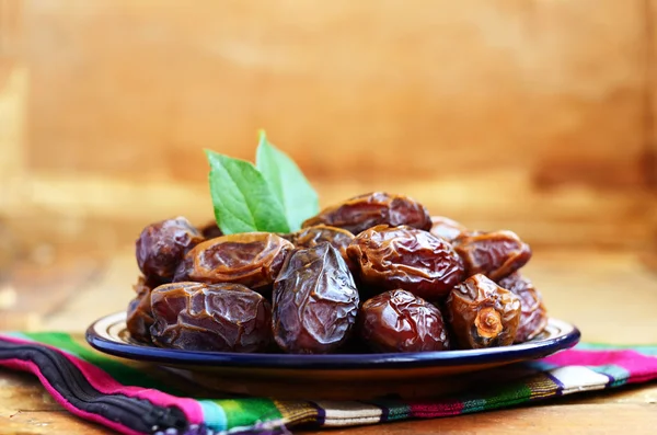 Date secche sul piatto di ceramica orientale — Foto Stock