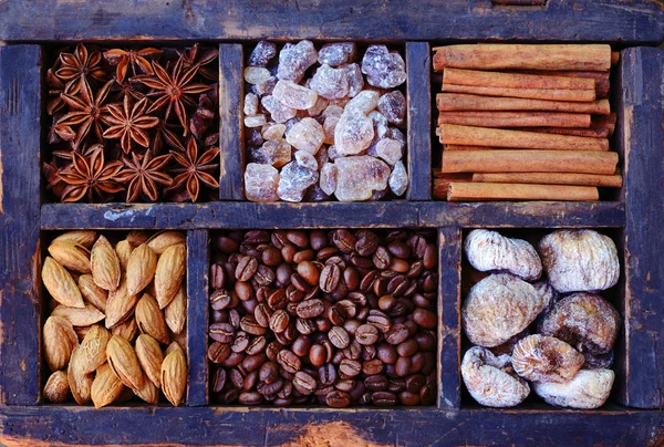 Conjunto de grãos de café, nozes e especiarias em exibição de madeira rústica — Fotografia de Stock
