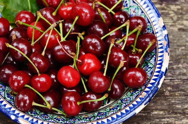 Sweet cherry in blue oriental bowl — Stock Photo, Image