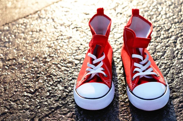 Pair of red trainers on asphalt — Stock Photo, Image