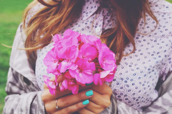 Elegante giovane donna che tiene in mano mazzo di fiori rosa — Foto Stock