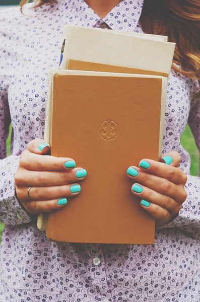 Young woman holding book pile in her hands — Stock Photo, Image