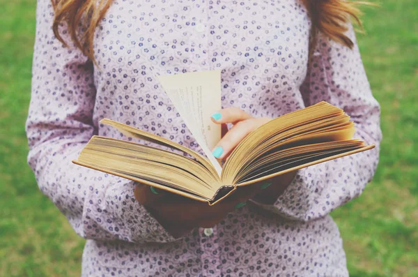 Ung kvinna med öppen bok i hennes händer — Stockfoto