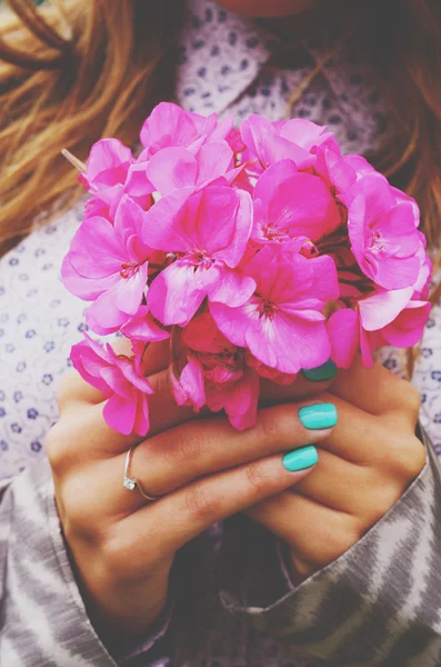 Stijlvolle dame bedrijf bos van roze bloemen in haar handen met thee Stockfoto
