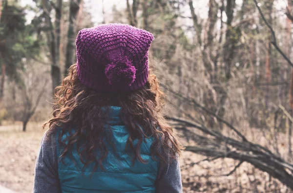 Curly hair woman in knitted hat in autumn forest — Stock Photo, Image