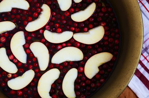 Voorbereiding van zoet en zuur cranberry met appels in messing kom — Stockfoto