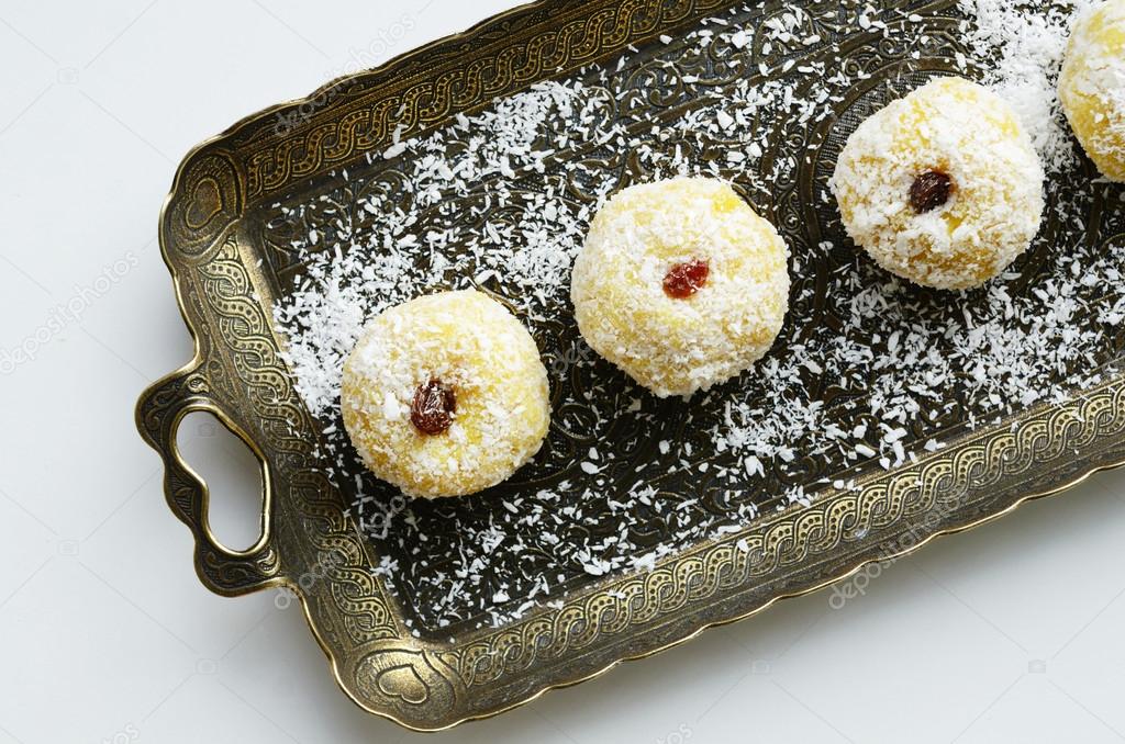 Laddu - coconut bites made of khee, coconut flakes, spices and topped with raisin