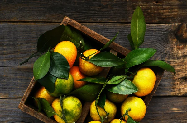 Čerstvé mandarinky v rustikální dřevěná truhla, pohled shora — Stock fotografie