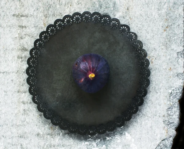 Одиночний фіолетовий інжир на металевій пластині, вид зверху — стокове фото