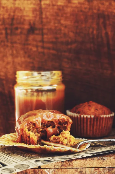 Zelfgemaakte wortel muffins en karamel saus op houten achtergrond — Stockfoto