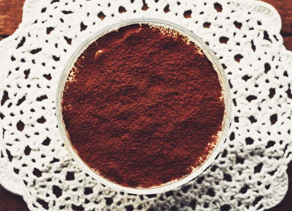 Tiramisu tatlı bir cam üzerinde dantel bardak altlığı peçete, üstten görünüm