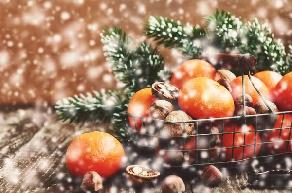 Vinter dekoration med mandariner och fallande snö — Stockfoto