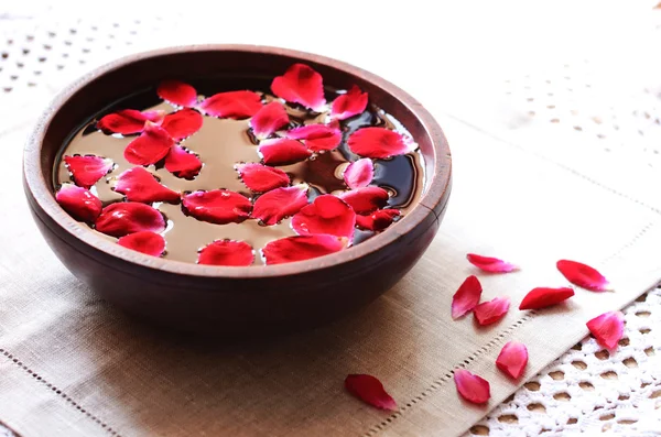 Деревянная чаша с плавающими красными лепестками роз — стоковое фото