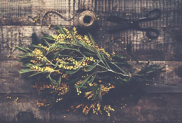 Ramo de mimosa, tijeras vintage y cuerda de yute sobre mesa de madera rústica —  Fotos de Stock