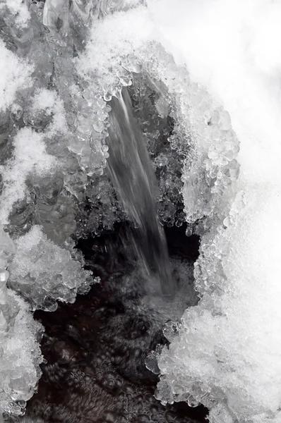 Água congelada, neve e pequena corrente — Fotografia de Stock