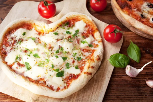 Romantische hartvormige Italiaanse pizza margherita Stockfoto