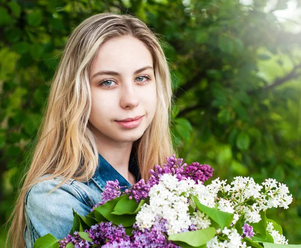 Flicka med en bukett av syrener — Stockfoto