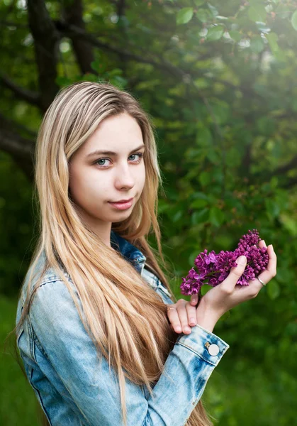 Flicka med en bukett av syrener — Stockfoto