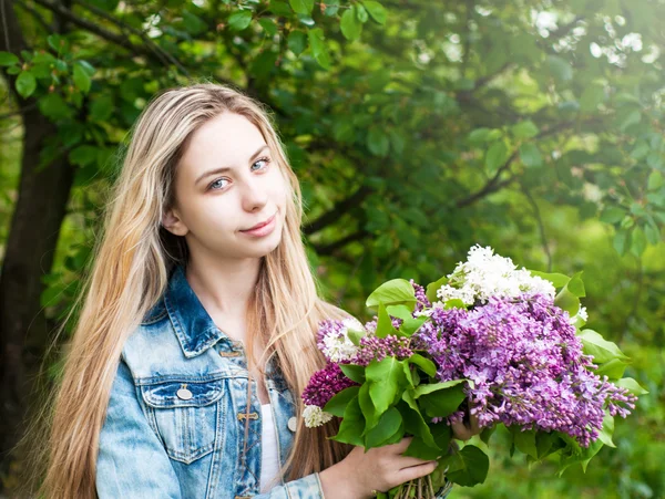 Flicka med en bukett av syrener — Stockfoto