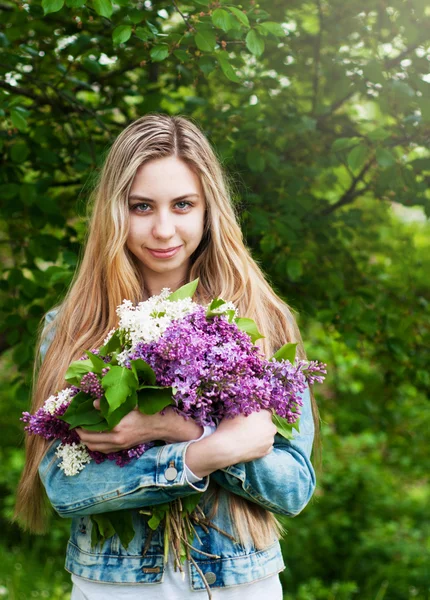 Flicka med en bukett av syrener — Stockfoto