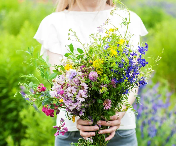 Vilda blommor i händerna — Stockfoto