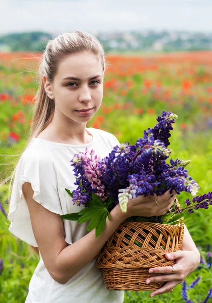 Flicka med korg av Lupin blommor — Stockfoto