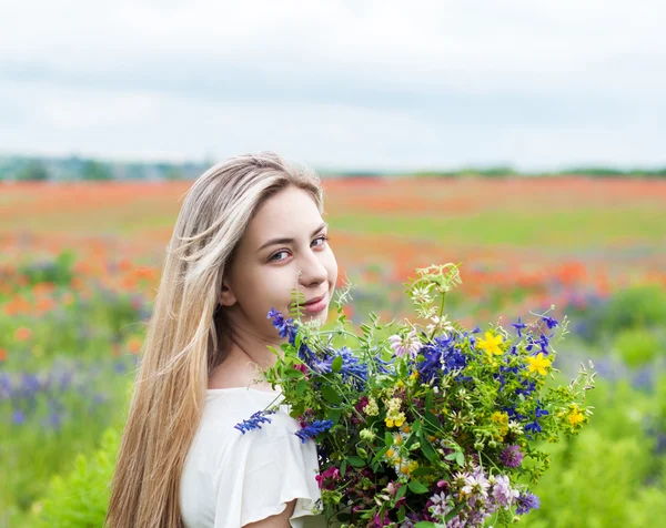 Kır çiçekleri ile güzel sarışın kız — Stok fotoğraf