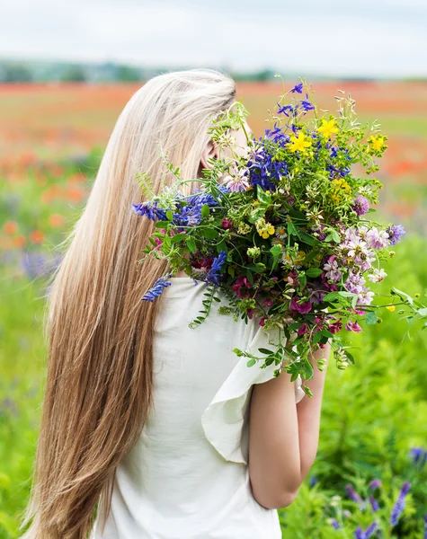 Vacker blond flicka med blommor — Stockfoto