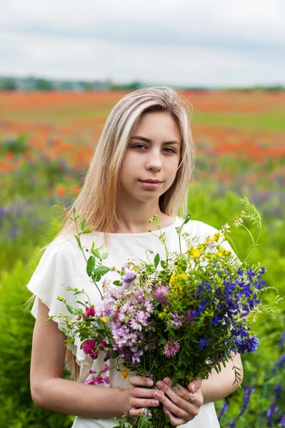 Krásná blonďatá dívka s květy — Stock fotografie