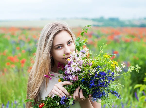 Kır çiçekleri ile güzel sarışın kız — Stok fotoğraf