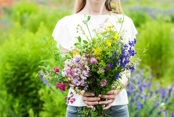 Vilda blommor i händerna — Stockfoto