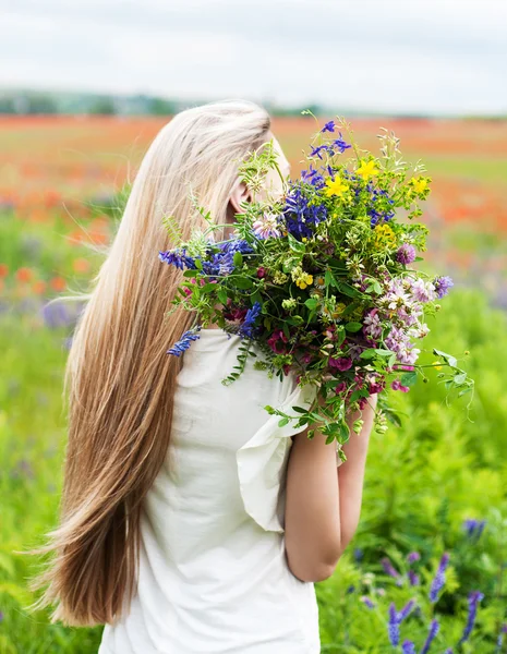 Vacker blond flicka med blommor — Stockfoto