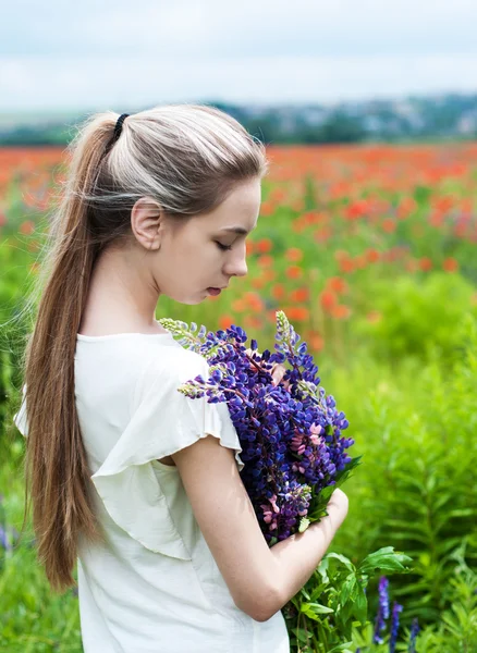 Flicka med blombukett Lupin — Stockfoto