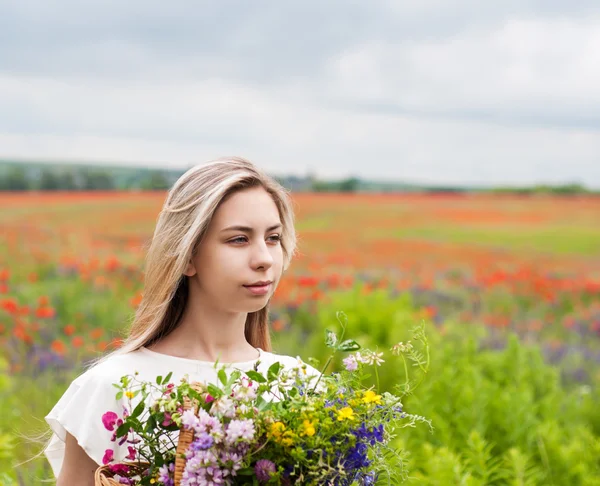 Vacker blond flicka med blommor — Stockfoto