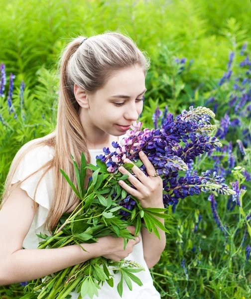 Flicka med blombukett Lupin — Stockfoto