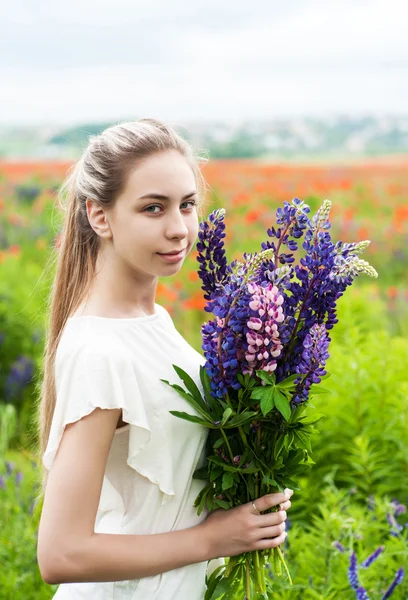 Flicka med blombukett Lupin — Stockfoto