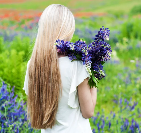 Flicka med blombukett Lupin — Stockfoto