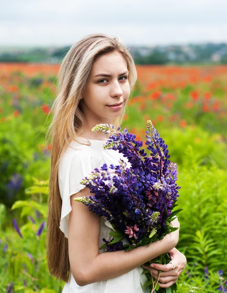 Menina com buquê de flores lupinas — Fotografia de Stock