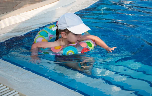 小さな女の子がプールで泳ぐ ストック写真