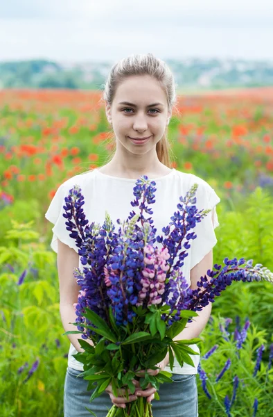 Menina com buquê de flores lupinas — Fotografia de Stock