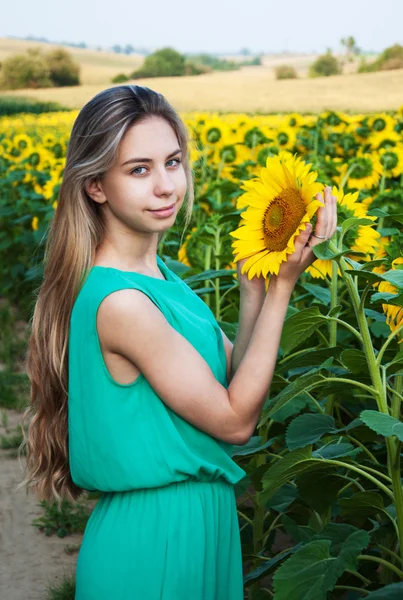 Flicka på fältet av solrosor — Stockfoto
