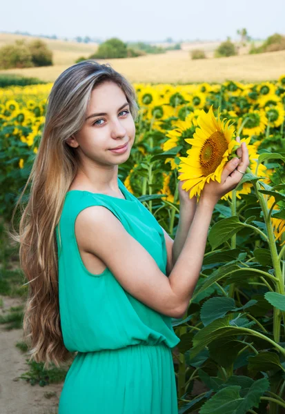 Flicka på fältet av solrosor — Stockfoto