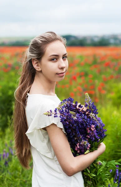 Flicka med blombukett Lupin — Stockfoto